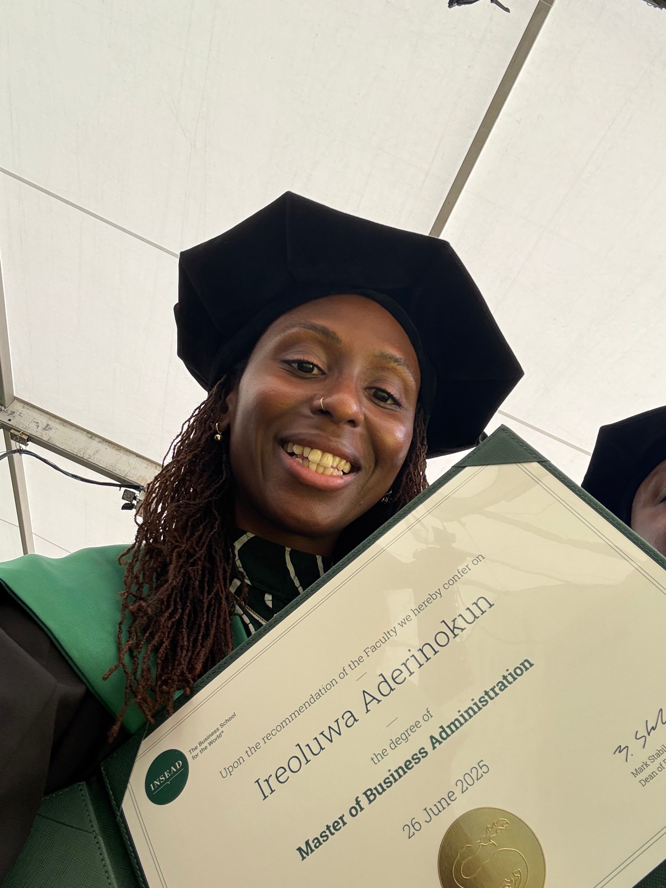 Graduation photo, Ire holding her INSEAD degree certificate